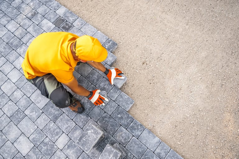 Skilled paving worker placing stones